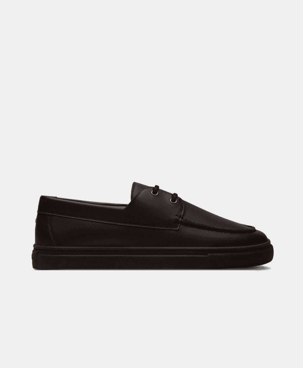 Side profile shot of a black leather ETQ boat shoe against a white background.