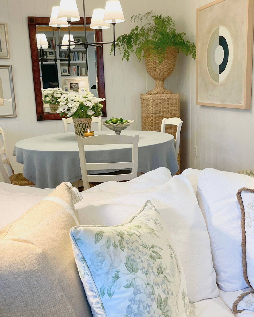 A bright white kitchen with fresh greenery and a cozy atmosphere.