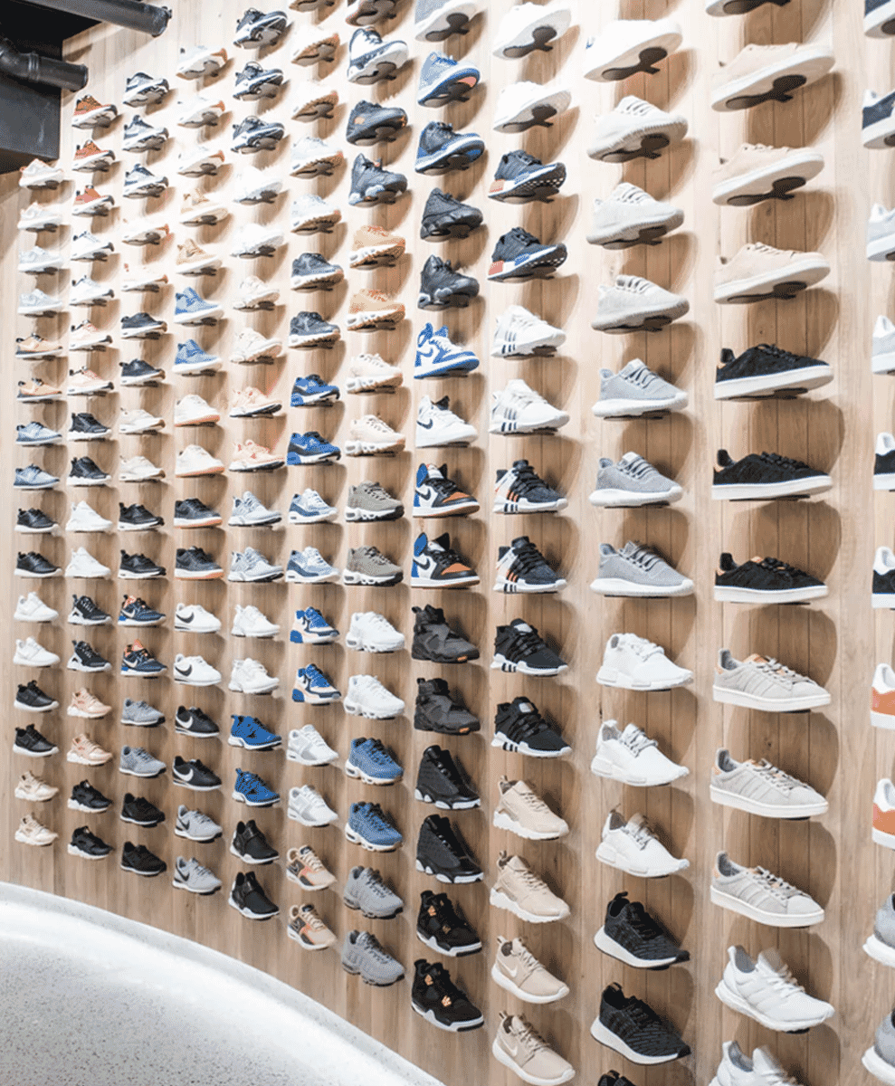 A wooden wall display featuring a curated collection of sneakers.