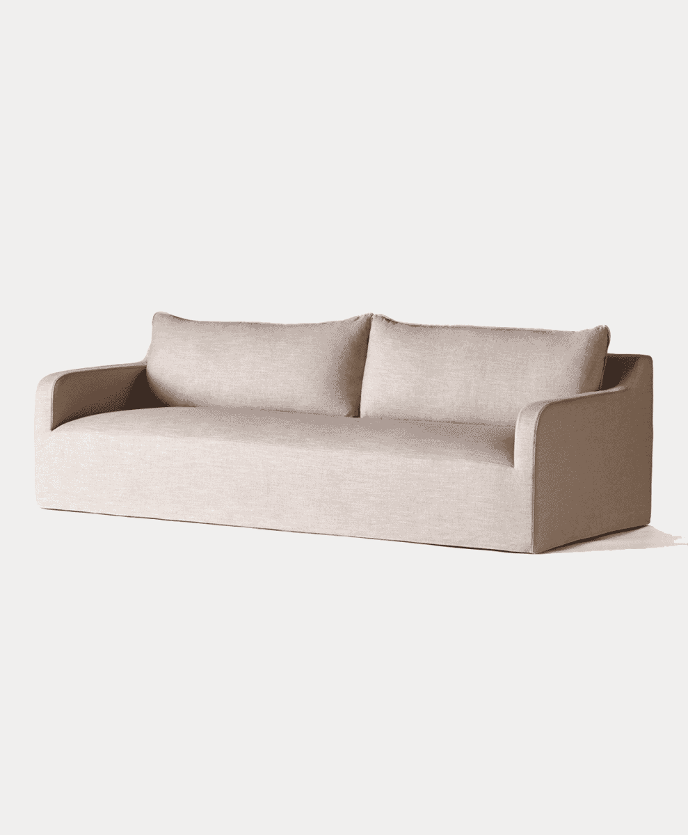 Modern low-profile beige fabric sofa isolated against a plain white studio background.