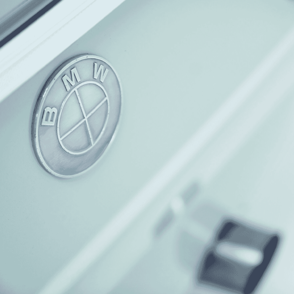 Macro close-up of a classic BMW logo on a car's hood.