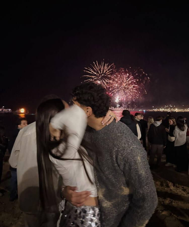 A romantic midnight kiss during a New Year's Eve celebration with soft lighting