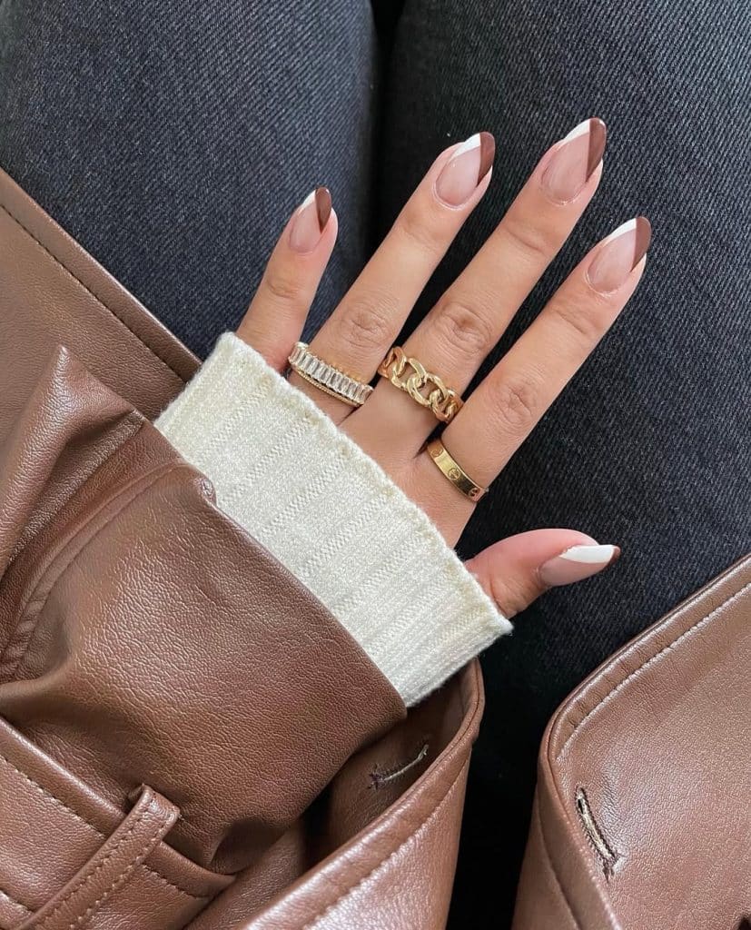 Brown and white manicure styled with a brown leather jacket, cream sweater, and blue denim.
