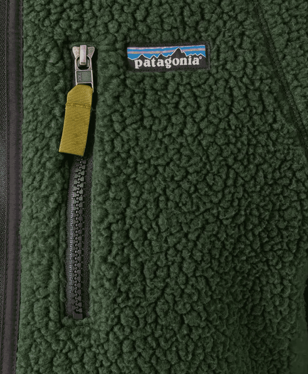 Close-up of a dark green textured fleece jacket with a yellow zipper pull.
