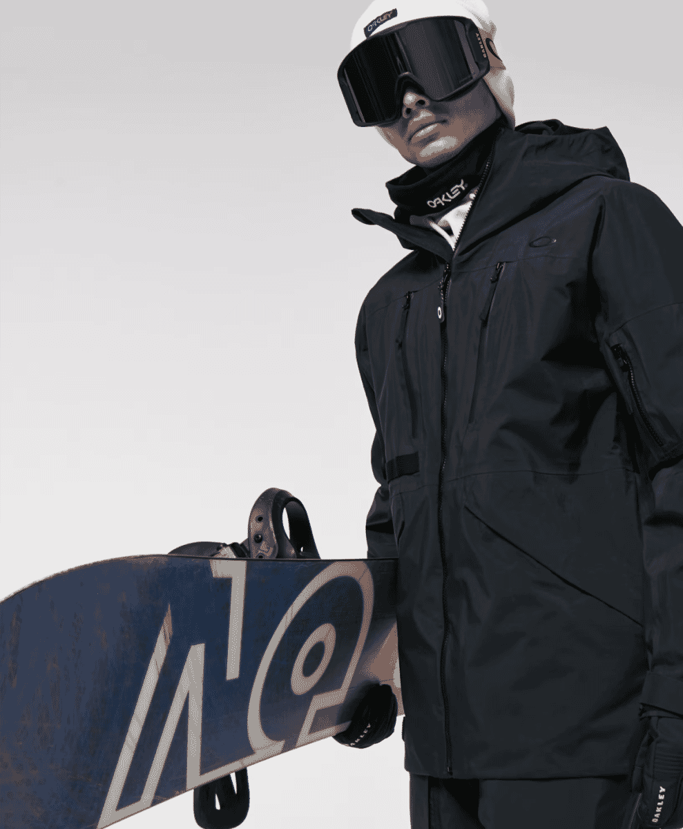 A close-up of a snowboarder in Oakley gear, focusing on protective goggles and helmet.
