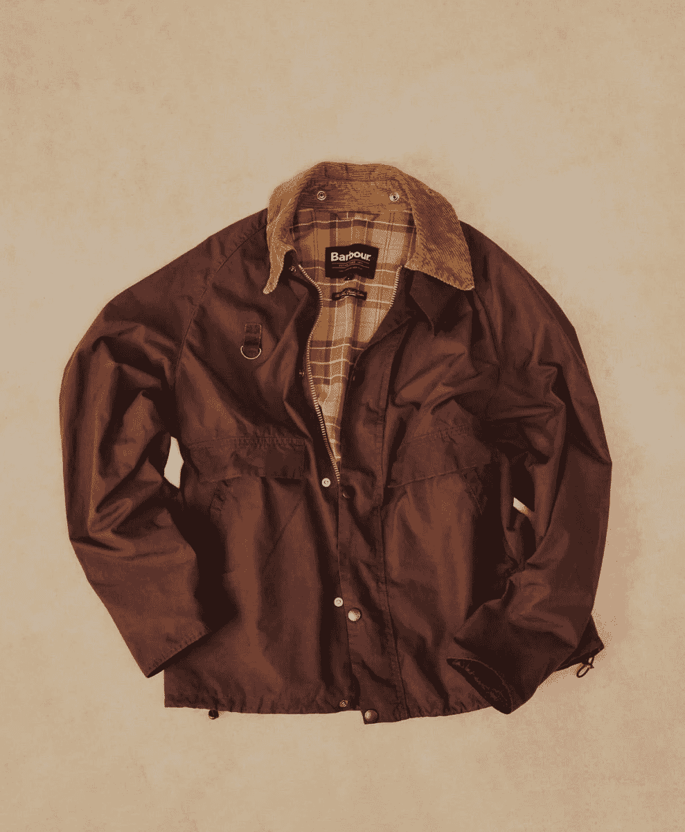 Flat lay of a brown Barbour jacket showing the corduroy collar and plaid interior lining.