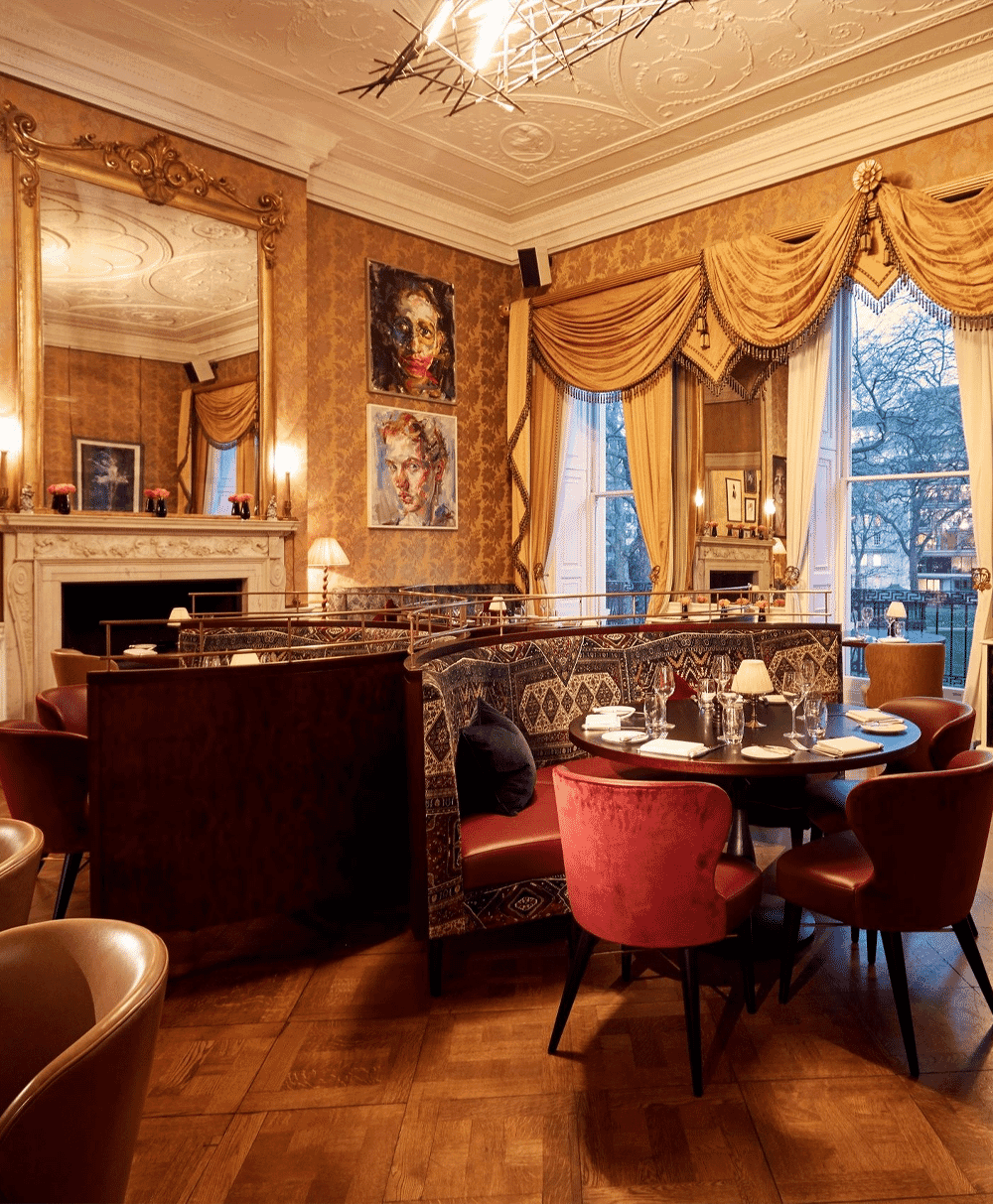 Elegant dining room with red velvet chairs and ornate banquette seating.