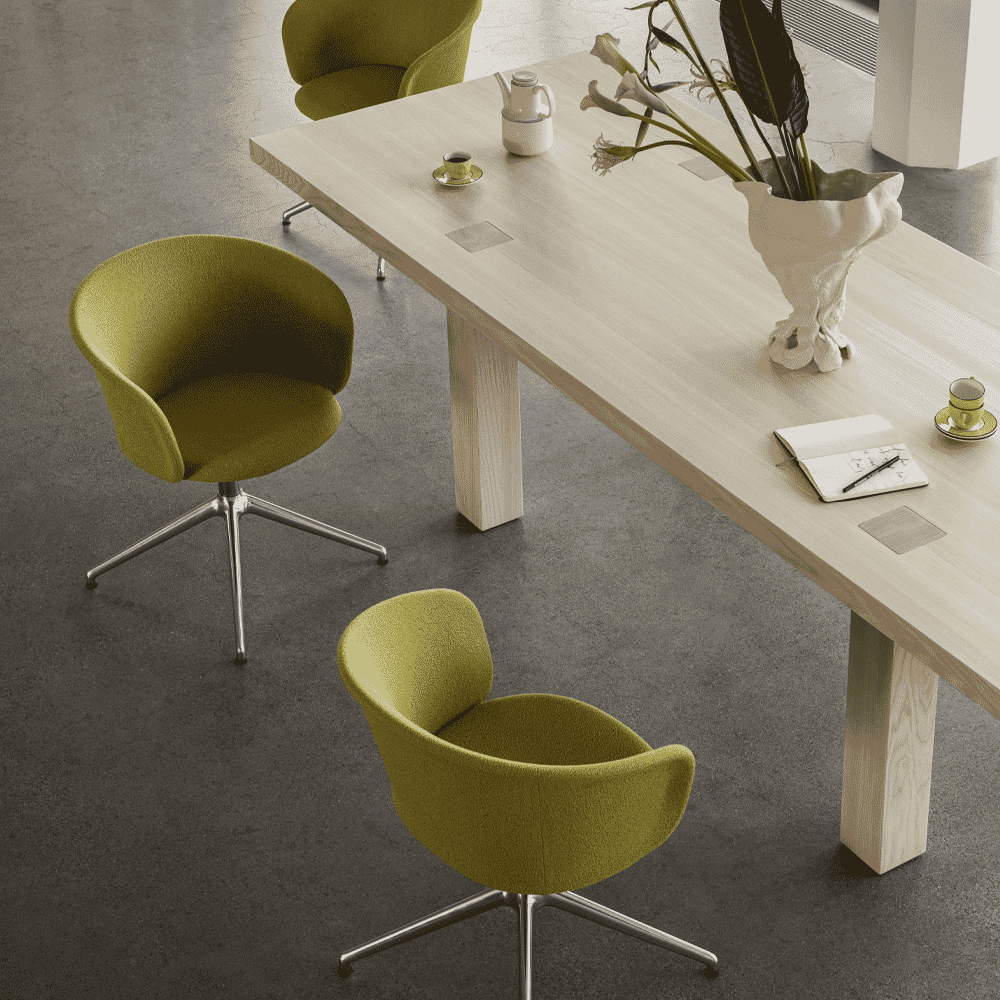 Vibrant lime green upholstered chairs surrounding a light-colored wooden conference table in a modern office.