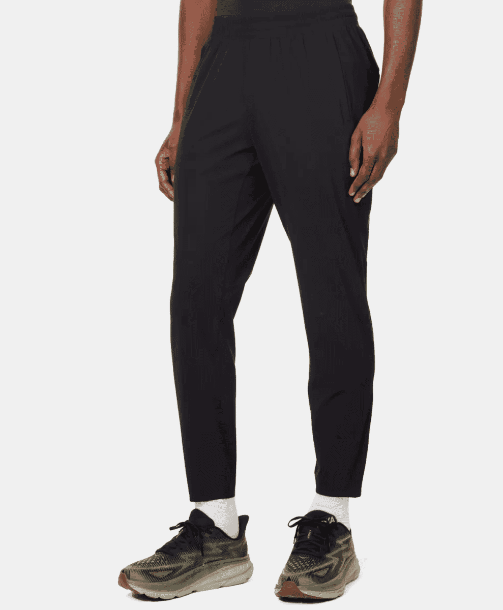 Model in black performance-style jogger pants and athletic sneakers.