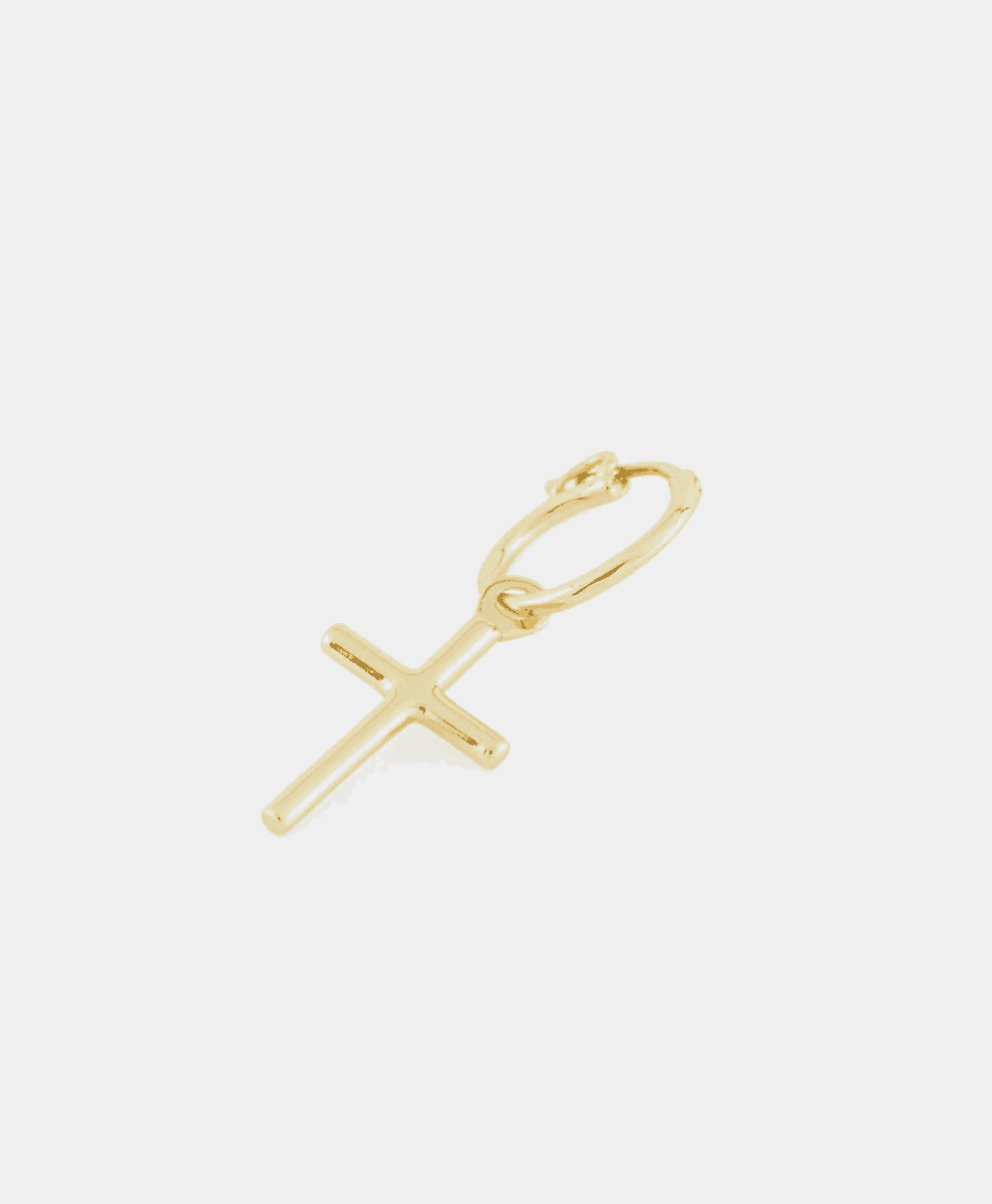 A delicate gold cross charm pendant against a white background.