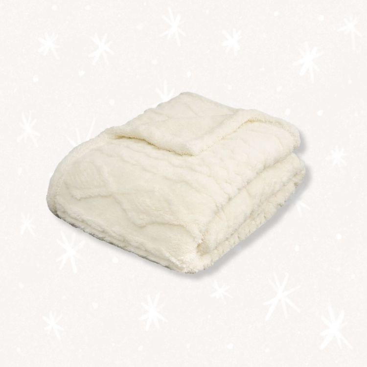 Fluffy white sherpa throw blanket folded neatly.