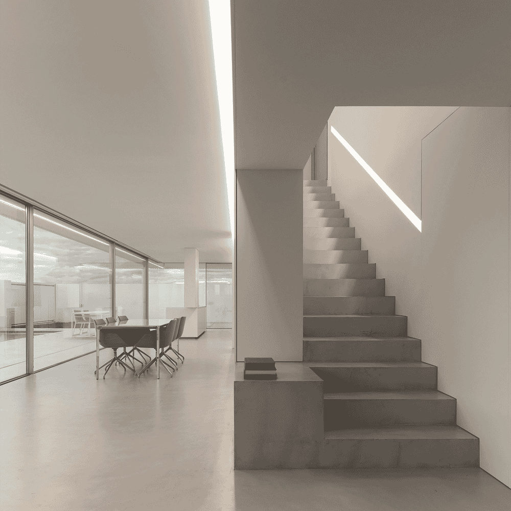 Architectural interior featuring a raw concrete staircase and glass-walled partitions.