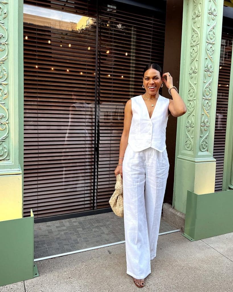 A woman wearing a flowing white maxi dress with delicate detailing.