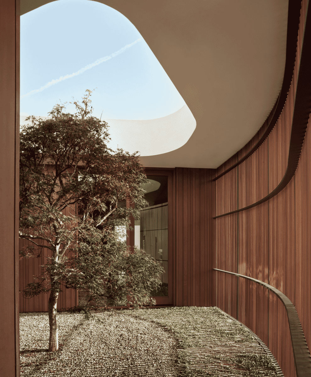 A minimalist courtyard with curved wooden walls and a gravel garden under an architectural ceiling opening.