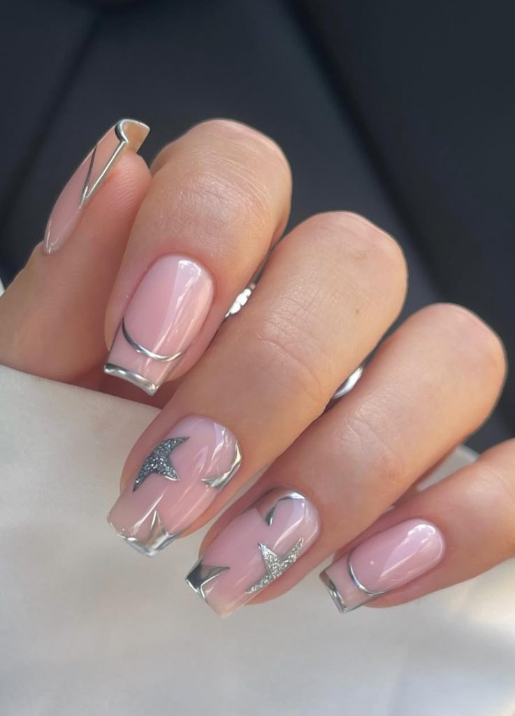 Gold metallic star decals on a neutral or sheer nail base.