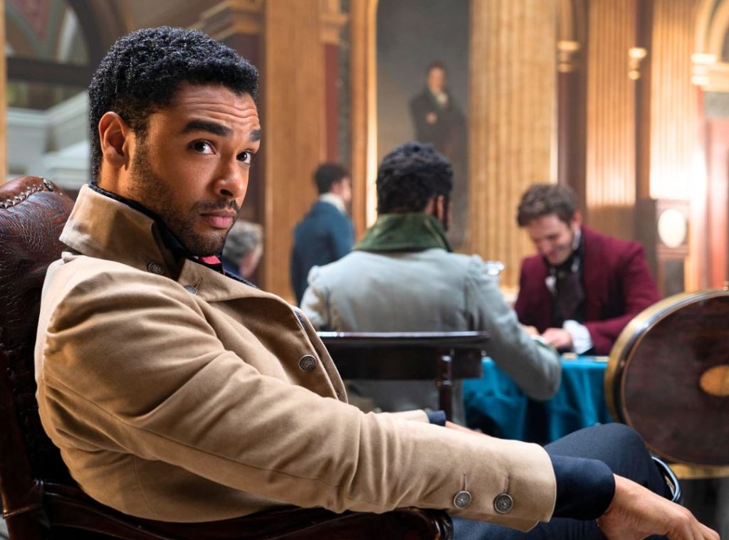Eloise Bridgerton holding a book and looking skeptical at a ball