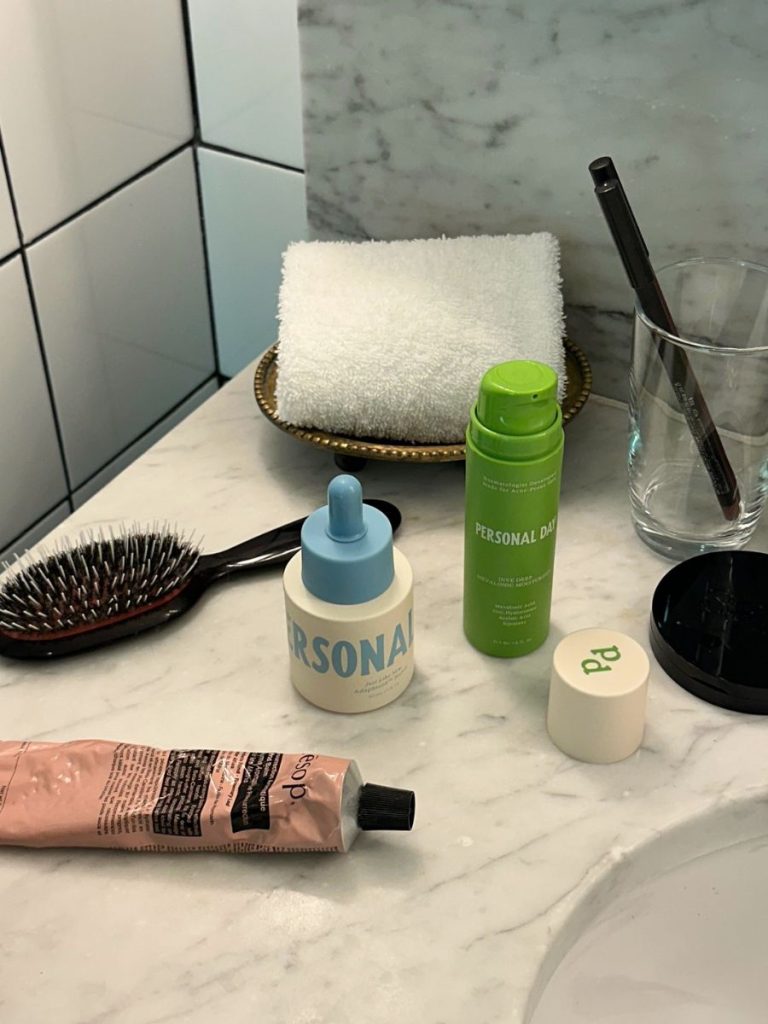 Selection of Personal Day skincare bottles and tubes arranged on a white bathroom counter