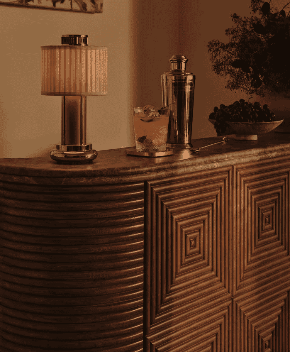 A vintage-style bar setup with a ribbed lamp and cocktail accessories.