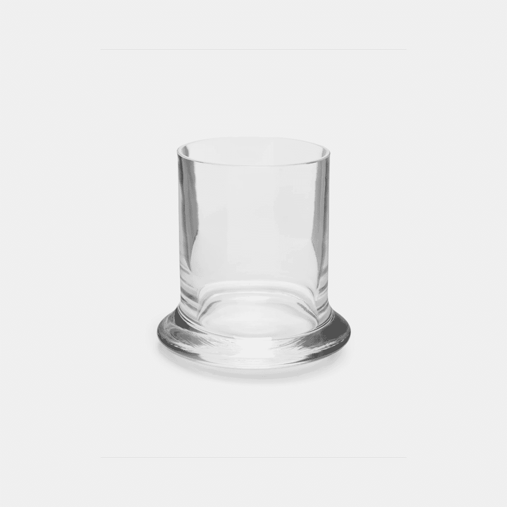 A transparent minimalist glass tumbler with a thick, heavy base on a white background.