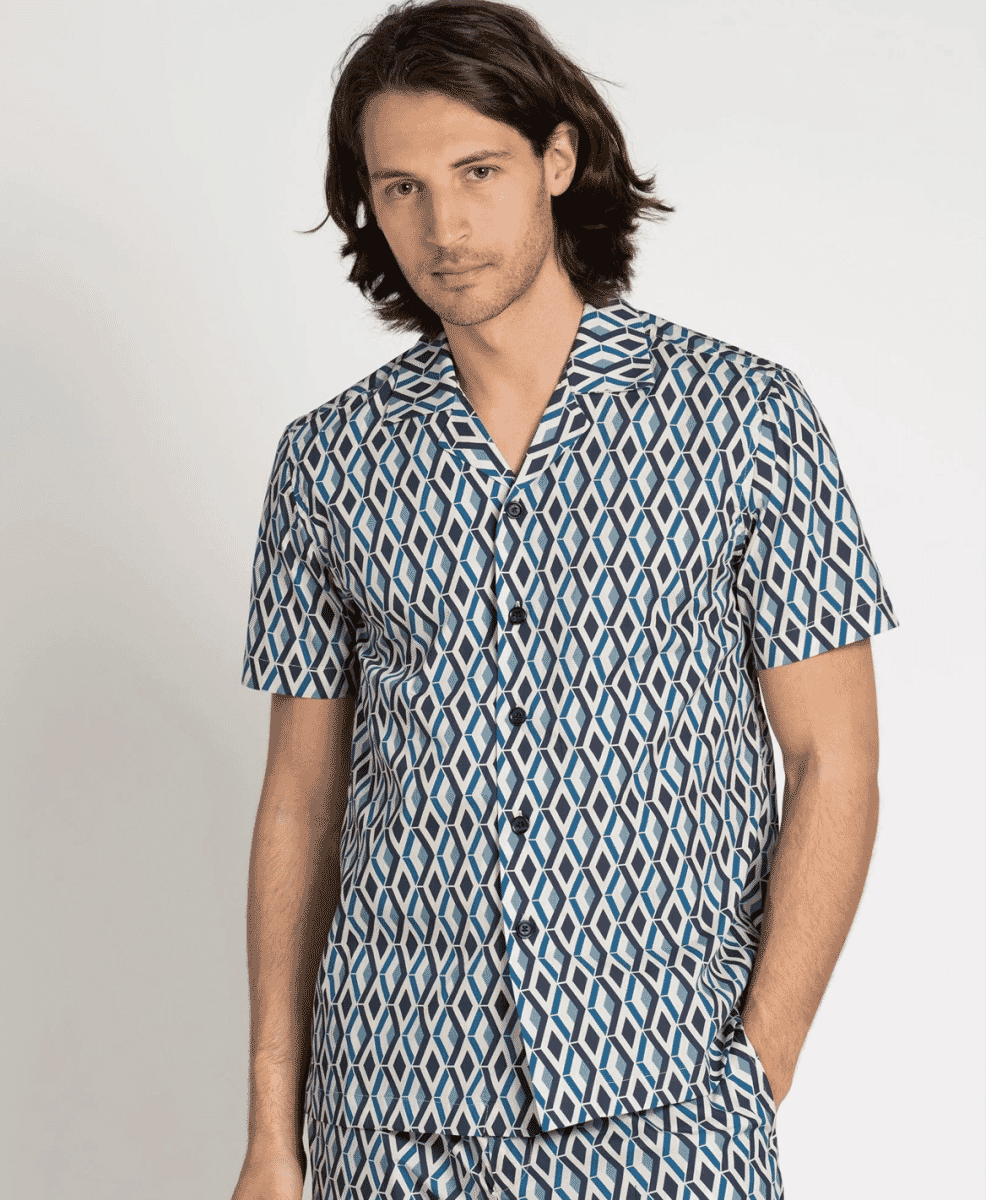 Man wearing a matching short-sleeved pajama-style shirt and shorts with a blue and white geometric pattern.