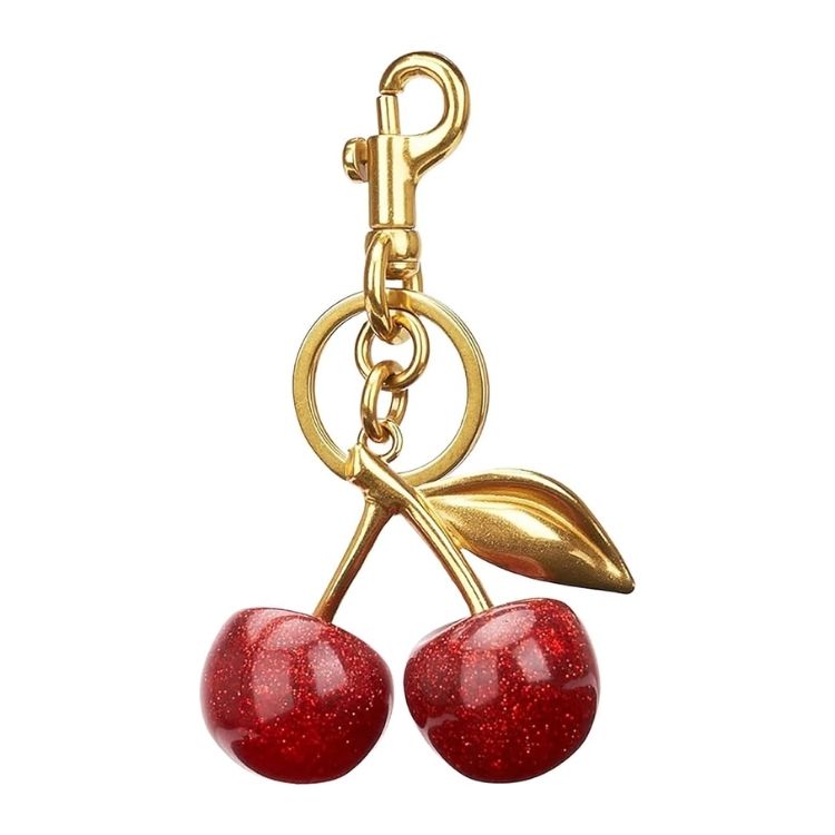A cherry-shaped keychain bag charm with red fruit and green leaves