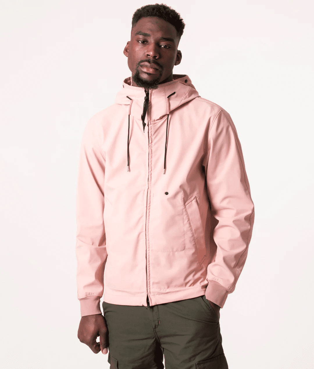 Model wearing a light pink hooded jacket with dark green utility pants.