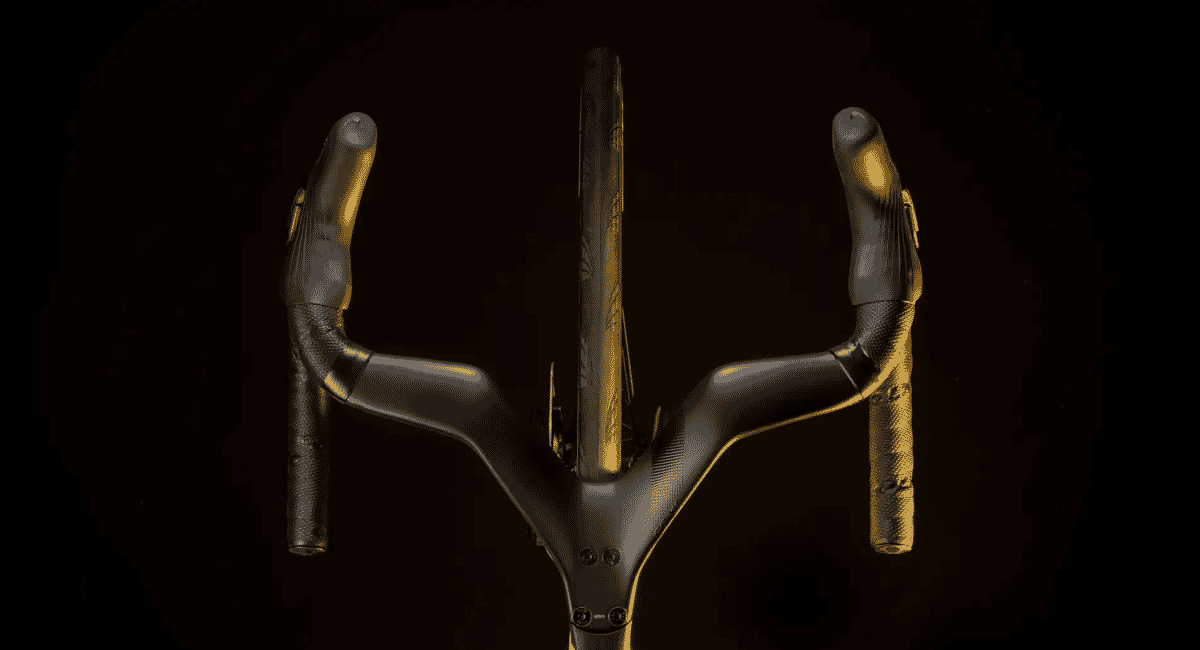Close-up of black carbon fiber bicycle handlebars with ergonomic grips in golden lighting.