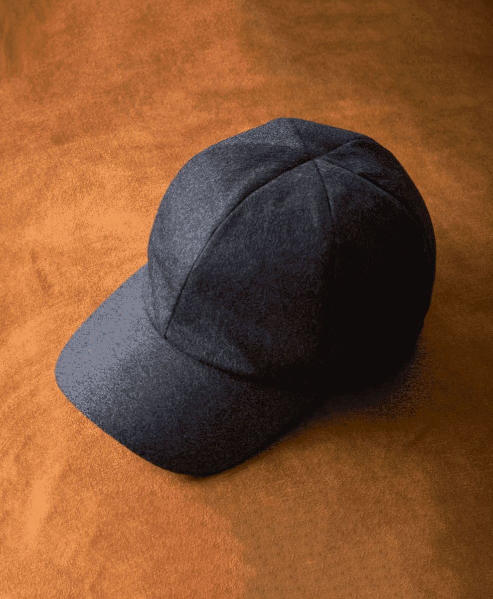 Dark gray wool cap on an orange textured surface.