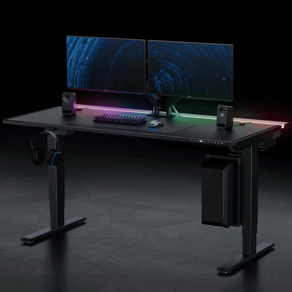 Modern black gaming desk with RGB lighting and dual monitor setup.