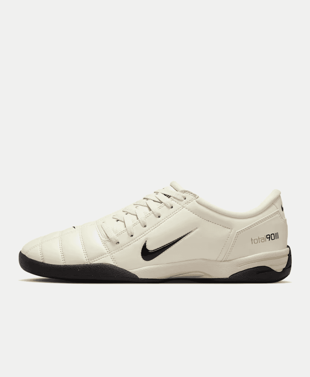 Side profile of a white and black Nike Total 90 III indoor soccer shoe.