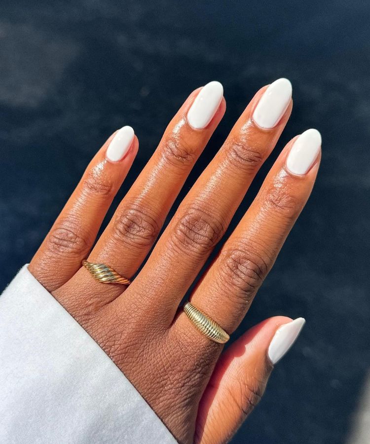 Crisp bright white manicure on short square nails.