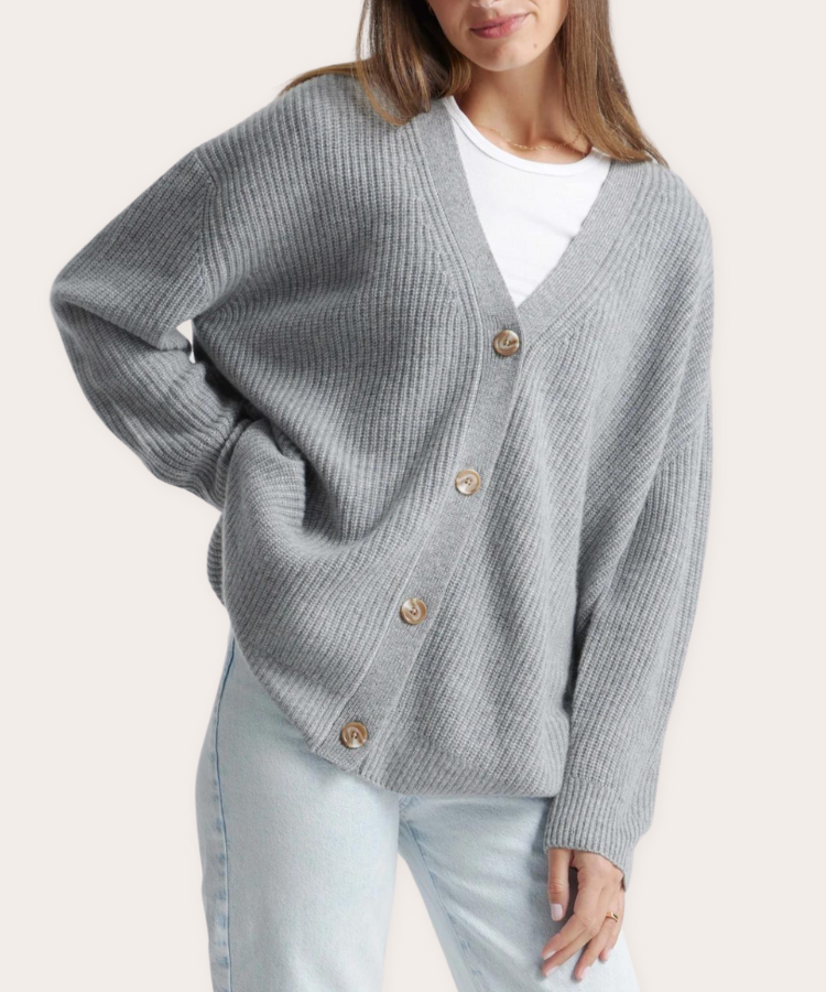 A woman wearing an oversized beige cashmere cardigan.