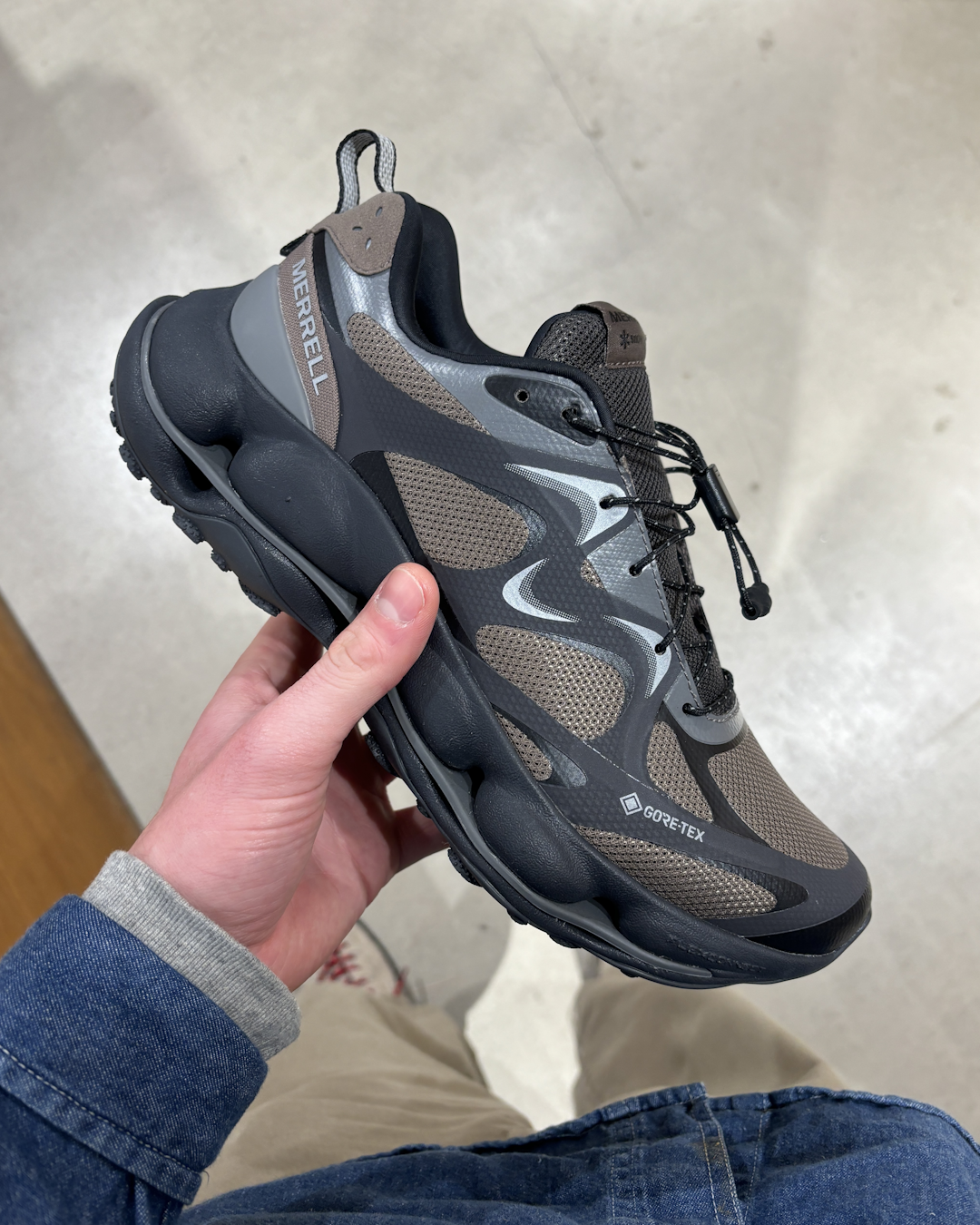 Close-up profile of the KHAKIS x New Balance 2010 sneaker featuring sandy beige tones with navy and red accents.