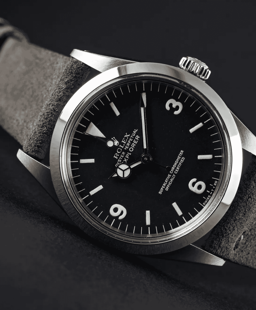 A vintage Rolex Explorer 1016 featuring its iconic 3-6-9 dial on a textured gray leather strap.