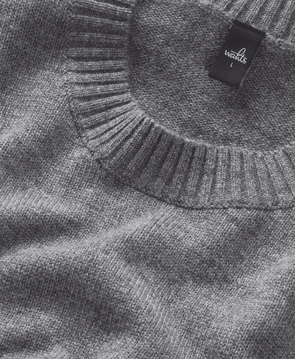 Detail shot of a gray ribbed crewneck sweater neckline.