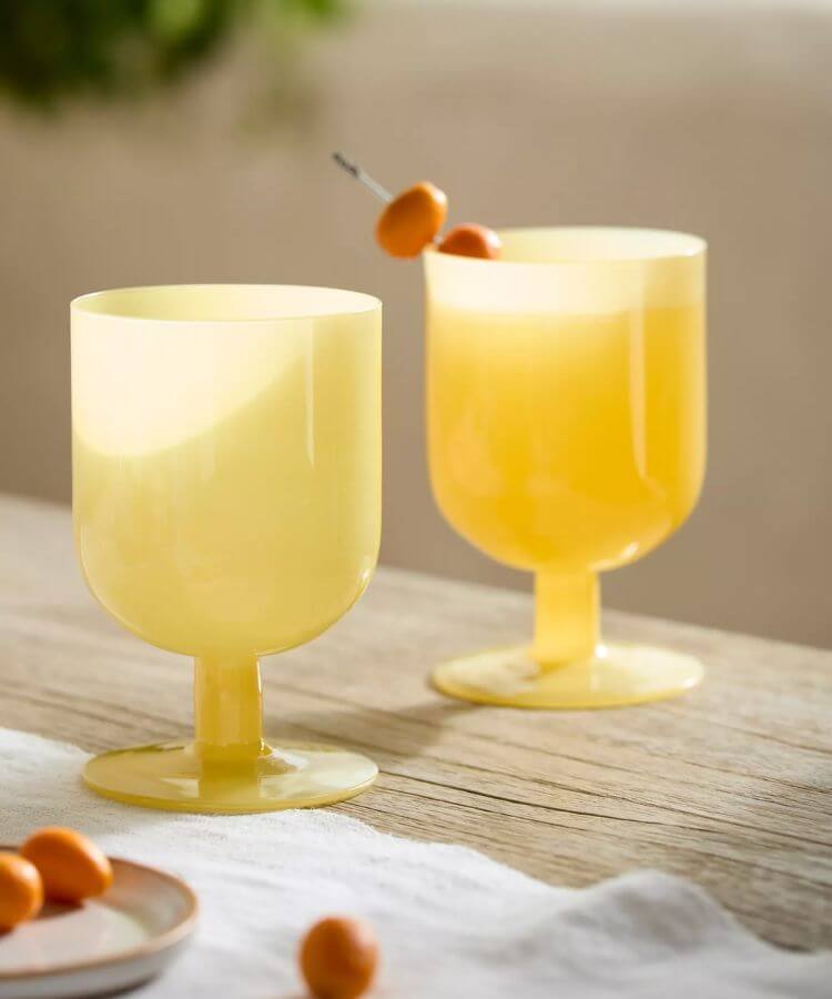 Set of two milky yellow footed drinking glasses.