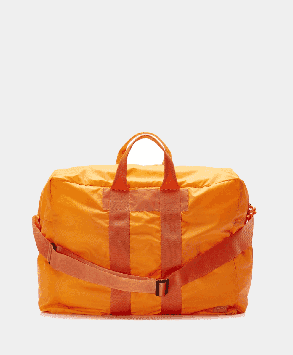 A vibrant orange Porter-Yoshida & Co. nylon duffel bag with black handles.