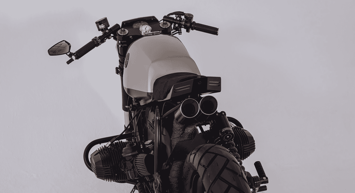 Rear-side perspective of a custom motorcycle showing the dual exhausts and aggressive stance.