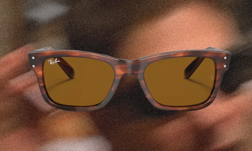 Ray-Ban tortoiseshell sunglasses with amber lenses on a textured brown background.