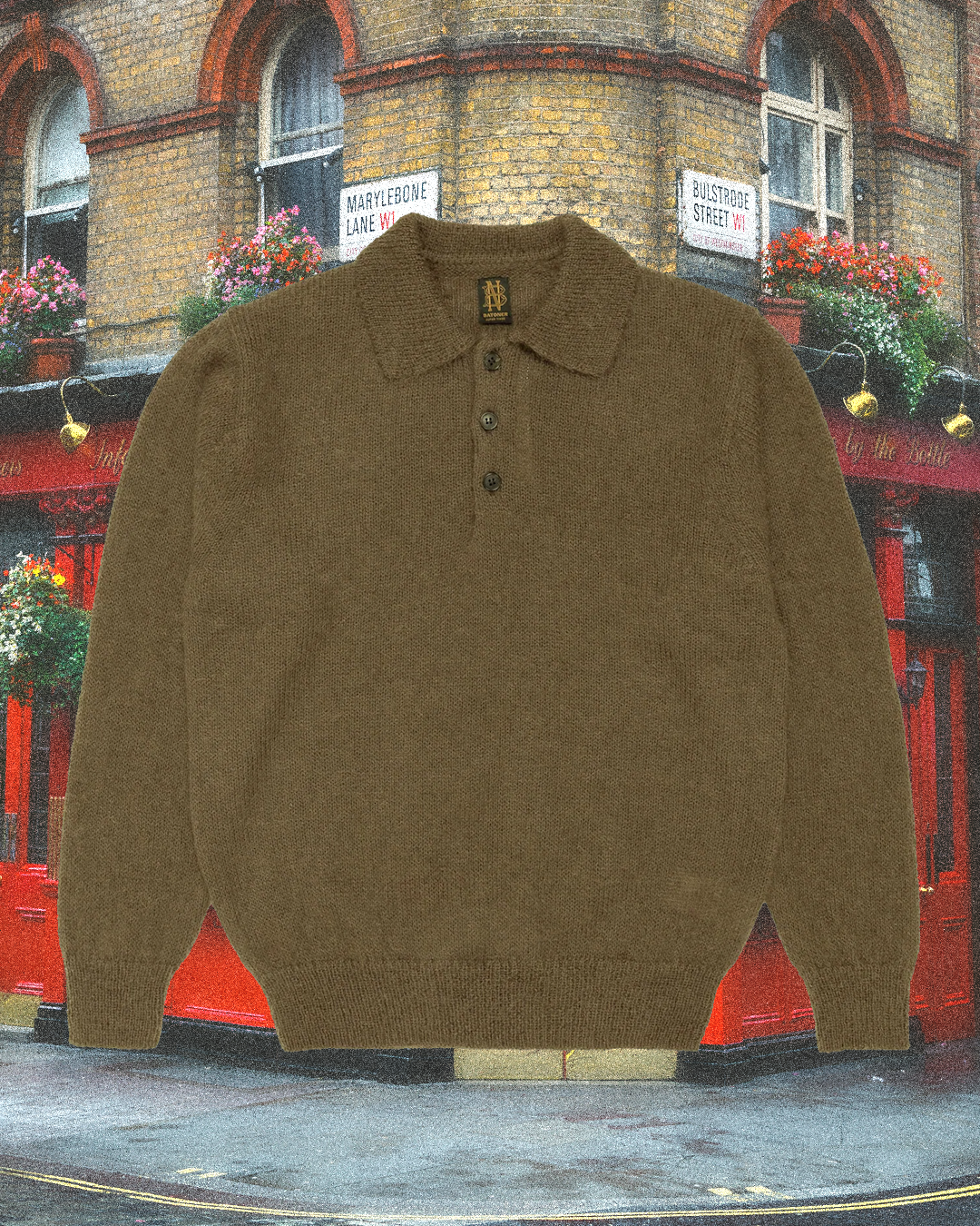 A brown knitted polo sweater with three buttons and a collar against a vibrant London pub backdrop.