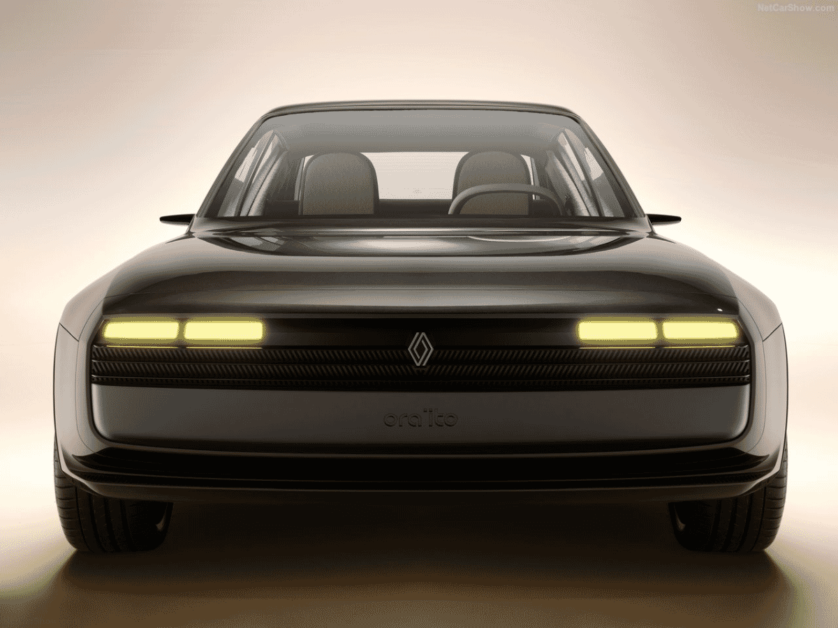 Front view of the Renault Ora Ïto electric concept car with glowing yellow headlights.
