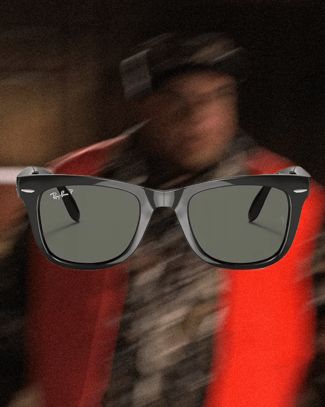 Person in a red coat and patterned scarf wearing black Ray-Ban Wayfarer sunglasses with motion blur.