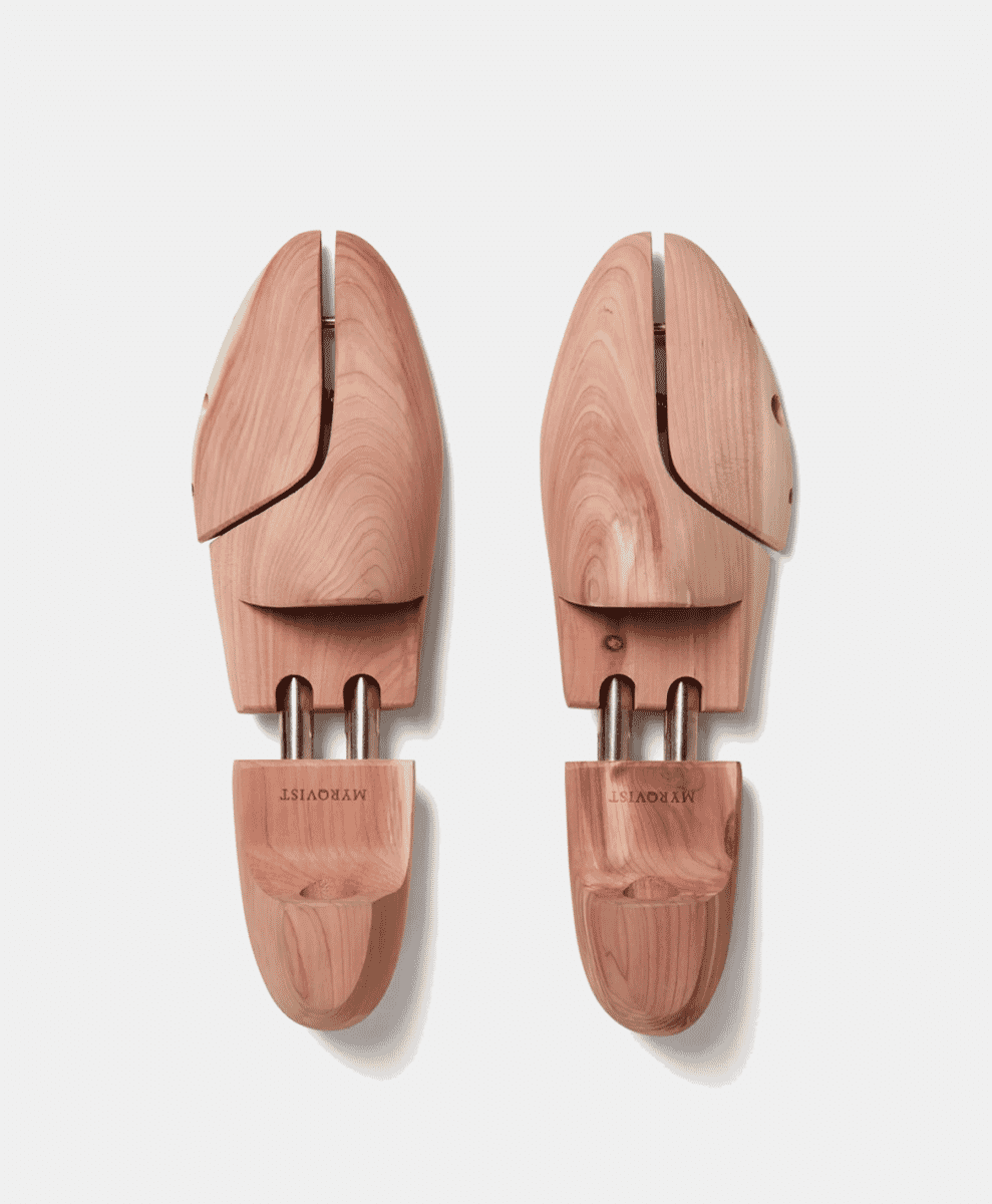Wooden shoe trees with metal adjustment rods on a white background.