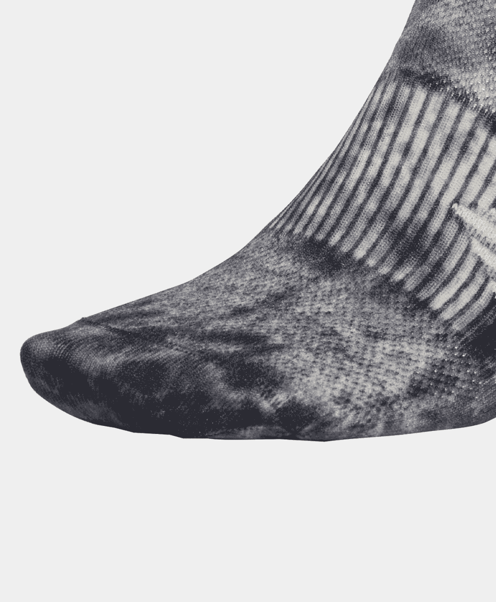 Close-up of a foot wearing a textured athletic sock with a ribbed cuff.
