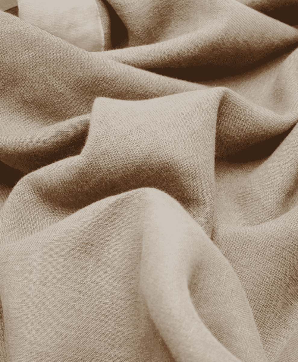 Close-up of textured beige linen fabric with soft natural folds.