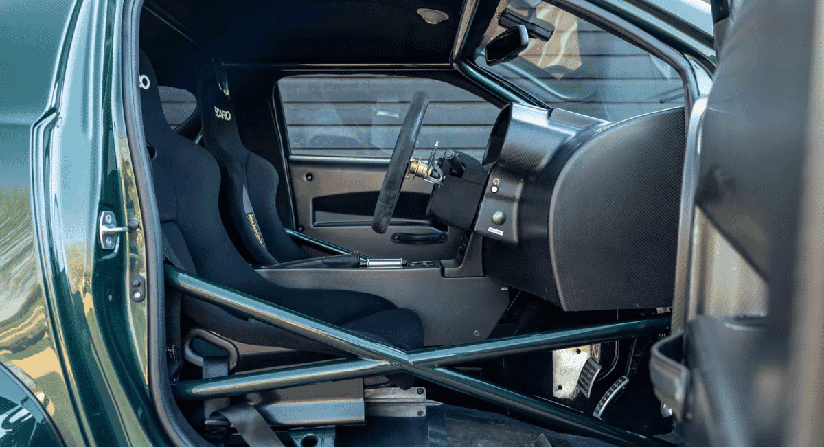 Interior of a sports car featuring Recaro racing seats and a visible roll cage.