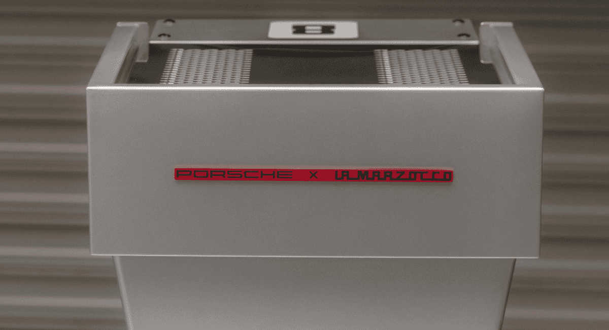 Close-up of the silver espresso machine featuring the Porsche x La Marzocco logo.
