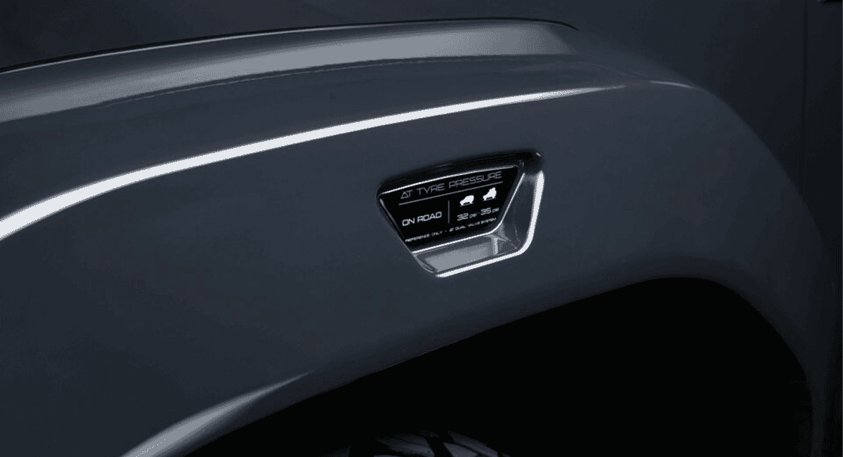 Close-up of the Arctic Trucks tire pressure monitoring system label on a dark gray fender.