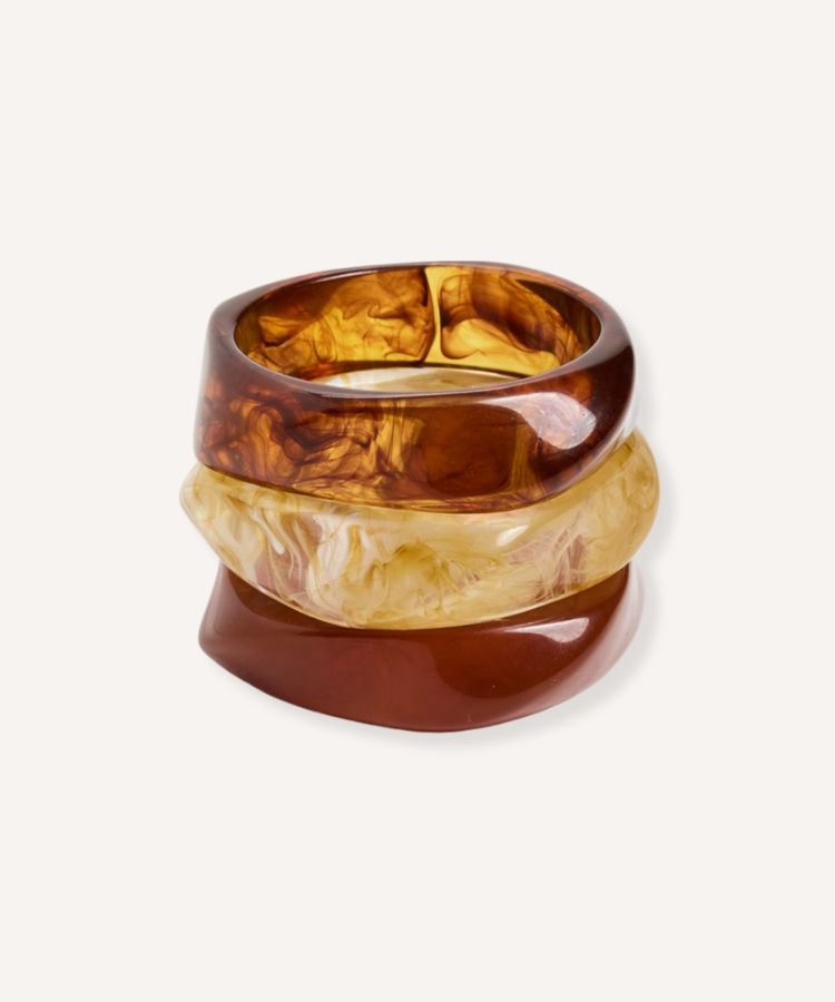 A set of tortoiseshell resin bangles stacked together.