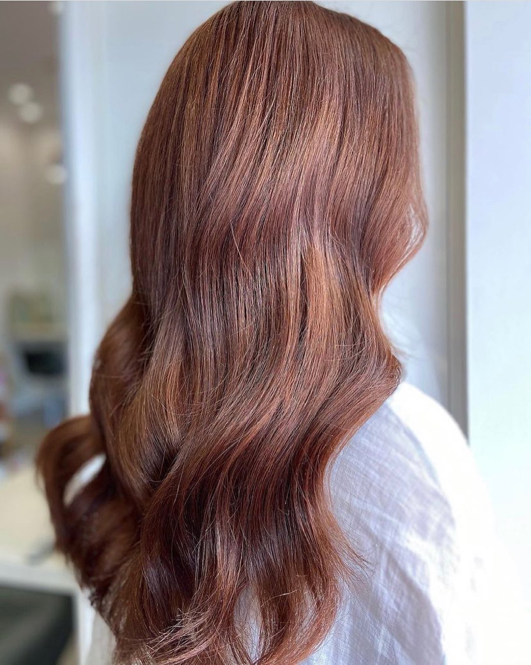 Dimensional hair color showing various shades of brunette and copper blended together.